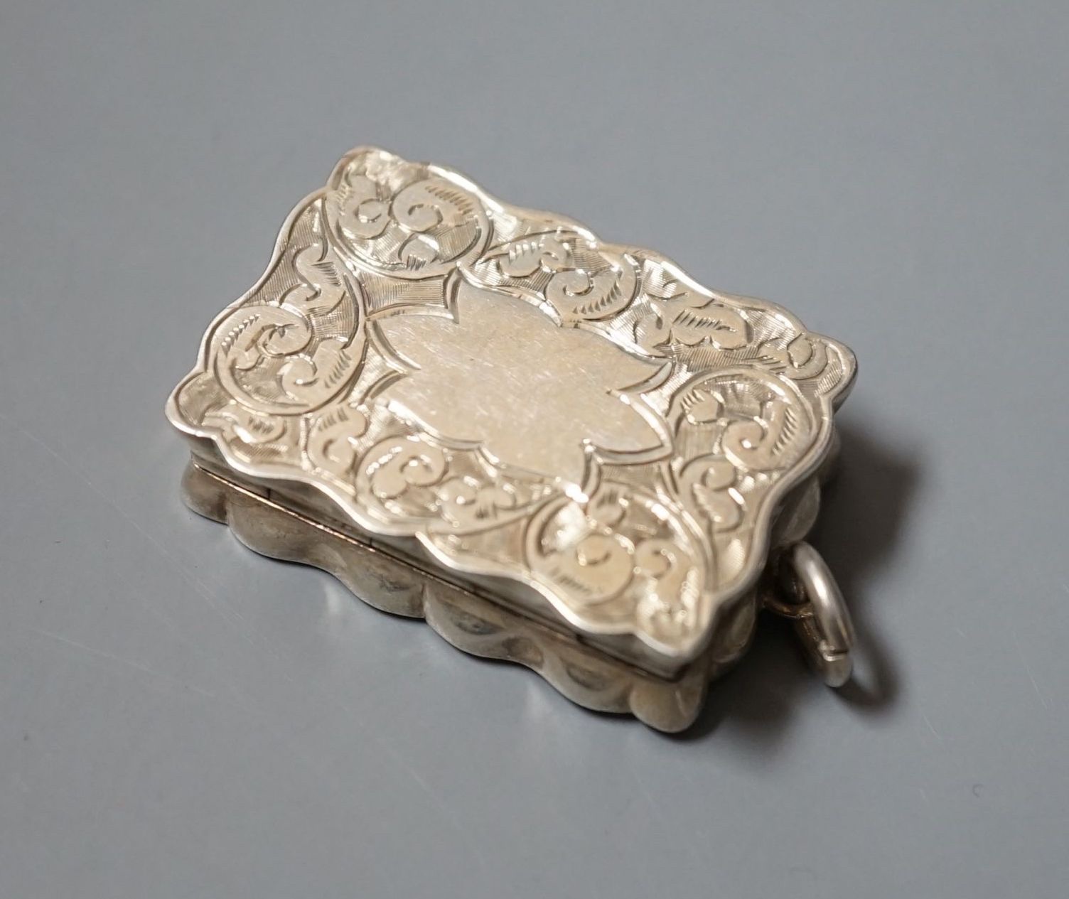 An Edwardian engraved silver shaped rectangular vinaigrette, Saunders & Shepherd, Birmingham, 1902, 38mm.
